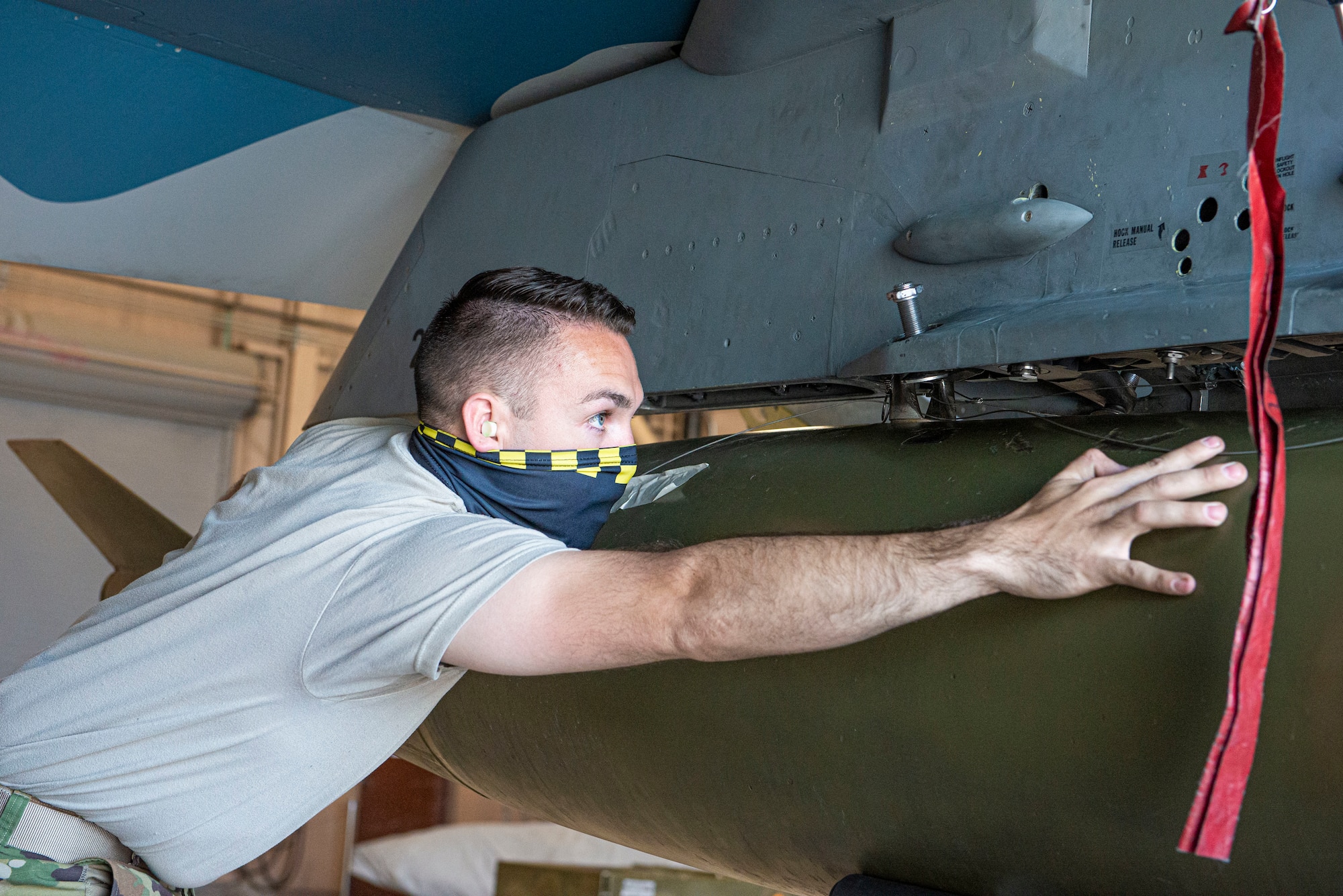 Senior Airman Rook Laird, 57th Maintenance Group Tomahawk Aircraft Maintenance Unit F-16 Fighting Falcon weapons load crew member, ensures a munition is secured during a weapons load certification.