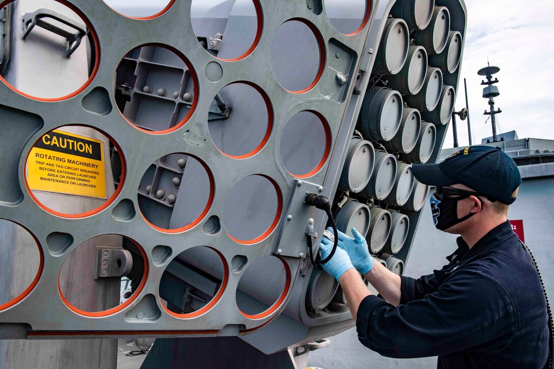 A sailor checks a rolling airframe missile weapons system.