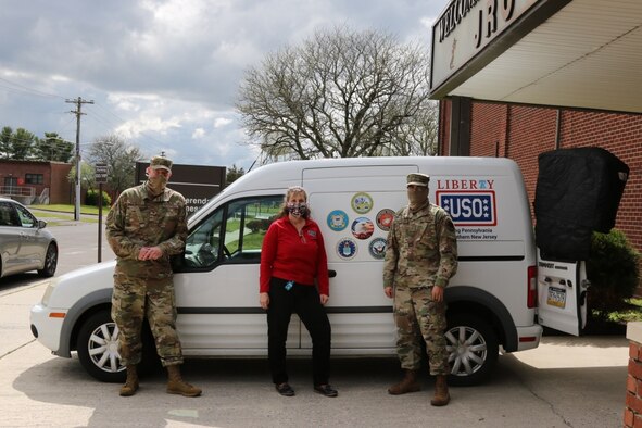 U.S. Air Force Chief Master Sgt. Len Werner and Staff Sgt. Kevin Bautista of 64th Air Expeditionary Group out of Joint Base McGuire-Dix-Lakehurst, N.J., stand with MJ Flammer, USO Southern New Jersey Operations Manager, to pose for a photo after snacks and drinks are delivered to the Joint Readiness Center at Joint Base McGuire-Dix-Lakehurst, N.J., This is one of six deliveries that have been made over the previous weeks for service members passing through before heading to their destination. U.S. Northern Command, through U.S. Army North, is providing military support to the Federal Emergency Management Agency to help communities in need. (U.S. Army photo by Spc. Chafelmer Kroll/RELEASED)
