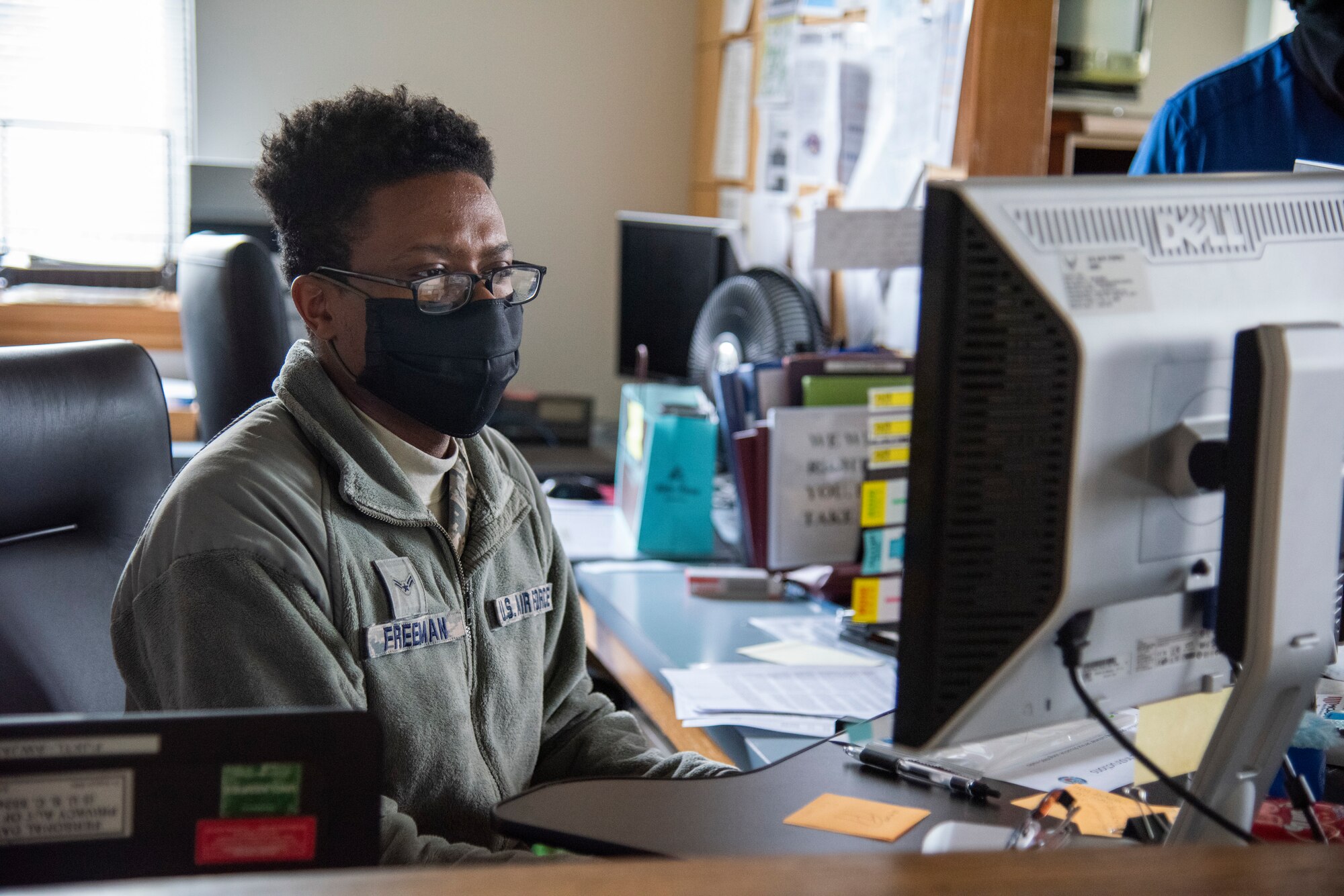 Airman 1st Class Malik Freeman, 436th Airlift Wing Legal Office paralegal, reviews information on a computer May 1, 2020, at Dover Air Force Base, Delaware. Freeman wears a mask in accordance with the Department of Defense instruction to reduce the spread of COVID-19. (U.S. Air Force photo by Airman 1st Class Jonathan Harding)