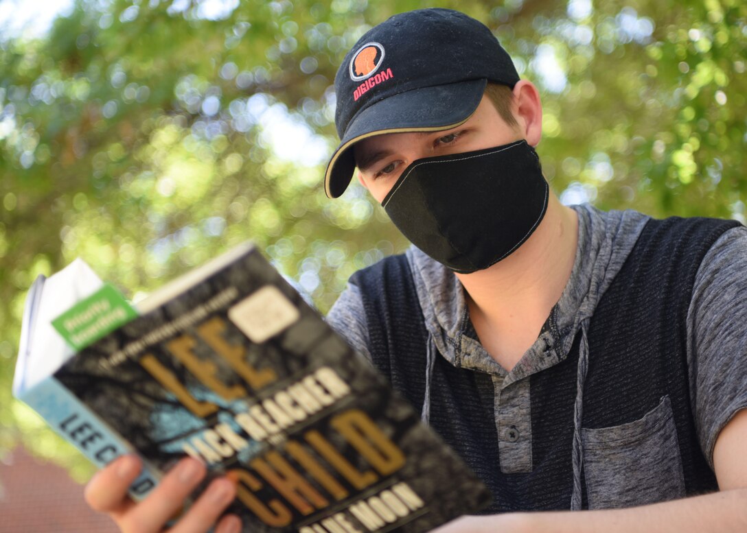 U.S. Air Force Airman 1st Class Michael Bowman, 17th Training Wing broadcast journalist, reads a book in the sun on Goodfellow Air Force Base, Texas, April 28, 2020. Doing some of your favorite hobbies is a good way to improve your mental health. (U.S. Air Force photo by Airman 1st Class Ethan Sherwood)