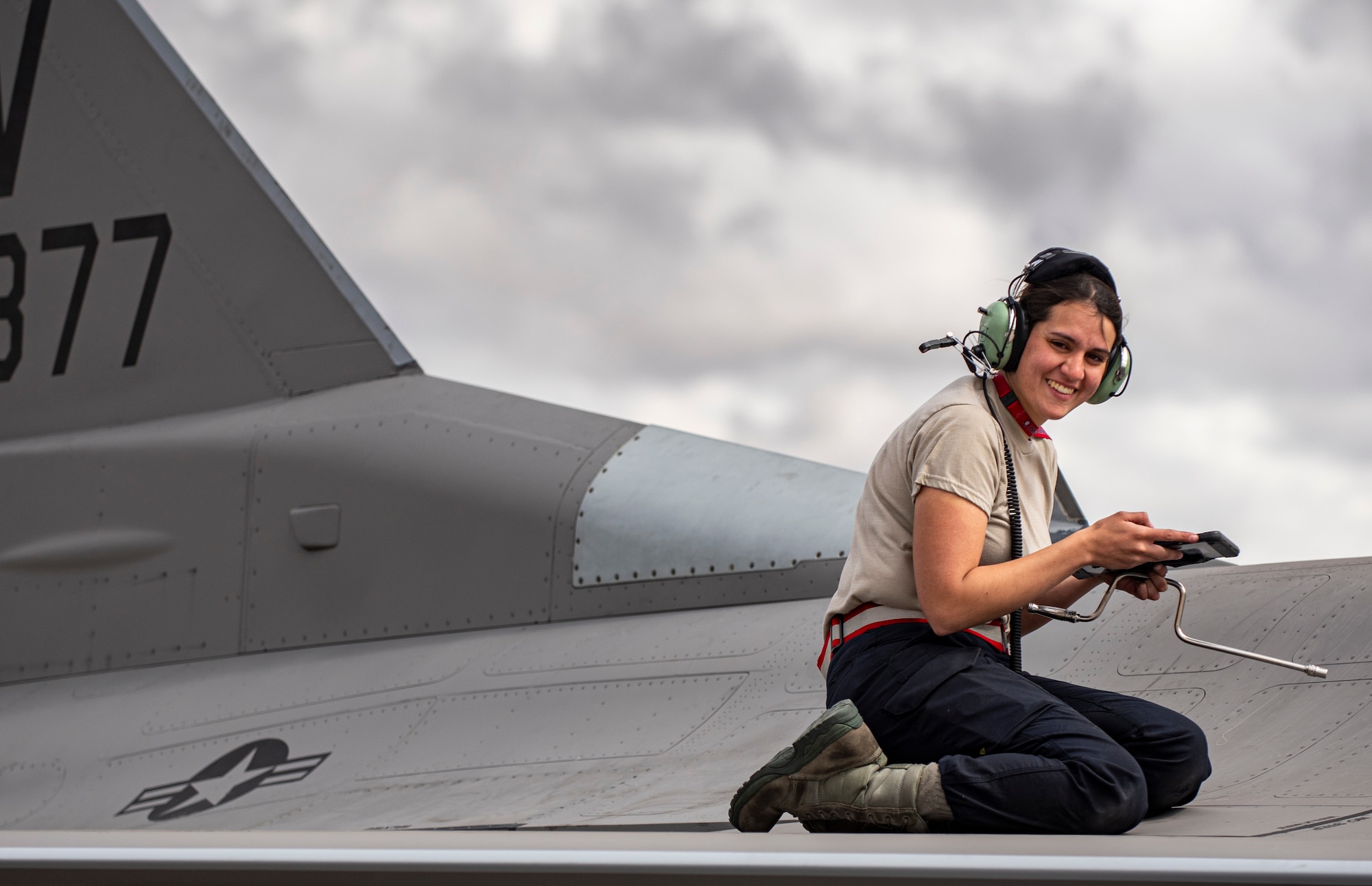 A picture of an Airman on top of a F-16.