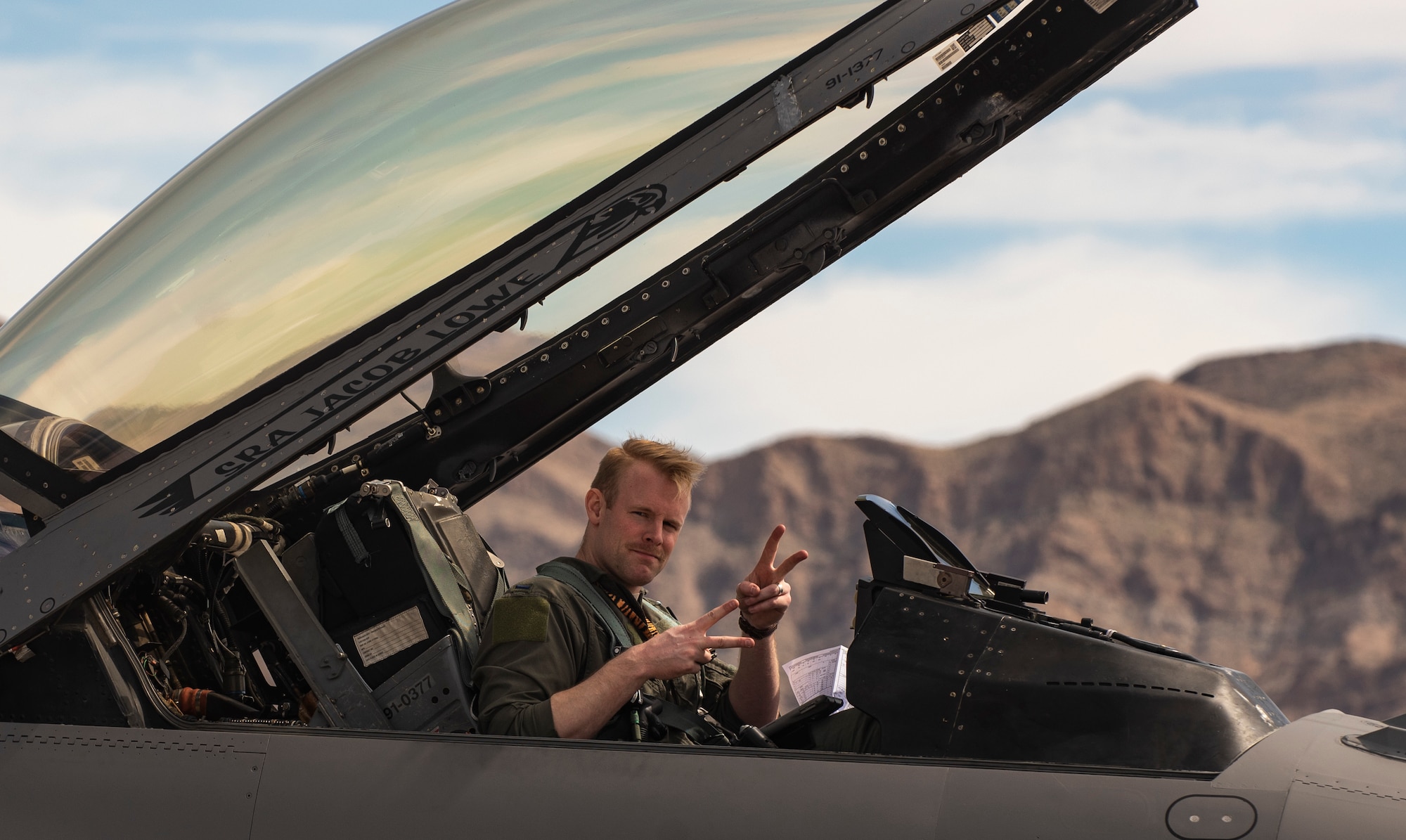 A picuture of a pilot sitting in the cockpit of a F-16.