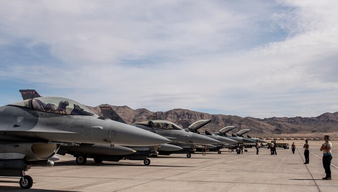 A picture of an Airman on top of a F-16.