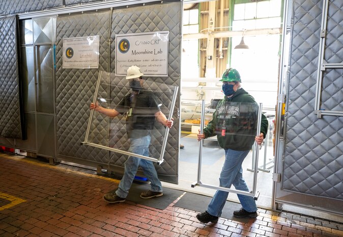 Leonard Lance and Kathy Wattam transport clean barrier made from vinyl in the Moonshine Lab at Puget Sound Naval Shipyard & Intermediate Maintenance Facility May 4. This team is part of a cadre of innovators taking on the challenge of designing and building protective barriers for customer facing interactions within the shipyard.