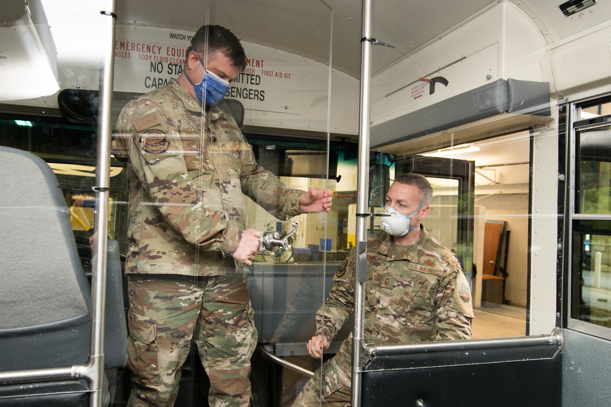 Lt. Col. Kevin Etherton, 436th Logistics Readiness Squadron commander and Senior Master Sgt. Troy Dubois, 436th Logistics Readiness Squadron Deployment and Distribution Flight superintendent, inspect the finished modifications to a transport bus April 27, 2020, at Dover Air Force Base, Delaware. Airmen of the 436th LRS installed a plexiglass partition between the driver’s seat and the passenger section on several buses to help mitigate the potential spread of COVID-19 while transporting aircrews to and from the flight line. (U.S. Air Force photo by Mauricio Campino)
