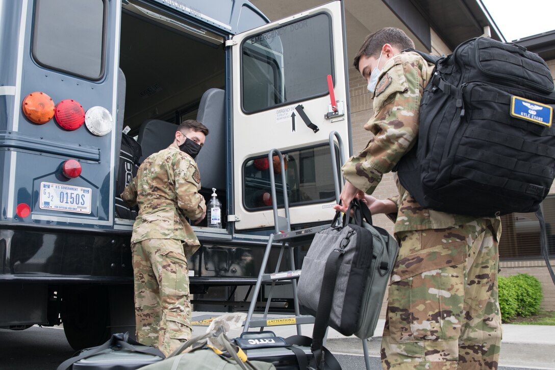A C-17 Globemaster III aircrew with the 3rd Airlift Squadron enter a transport bus using the rear emergency door, May 1, 2020, at Dover Air Force Base, Delaware. Entering from the rear of the bus and the installation of a  plexiglass partition between the driver’s seat and the passenger section to help mitigate the potential spread of COVID-19 while transporting air crews to and from the flightline. (U.S. Air Force photo by Mauricio Campino)