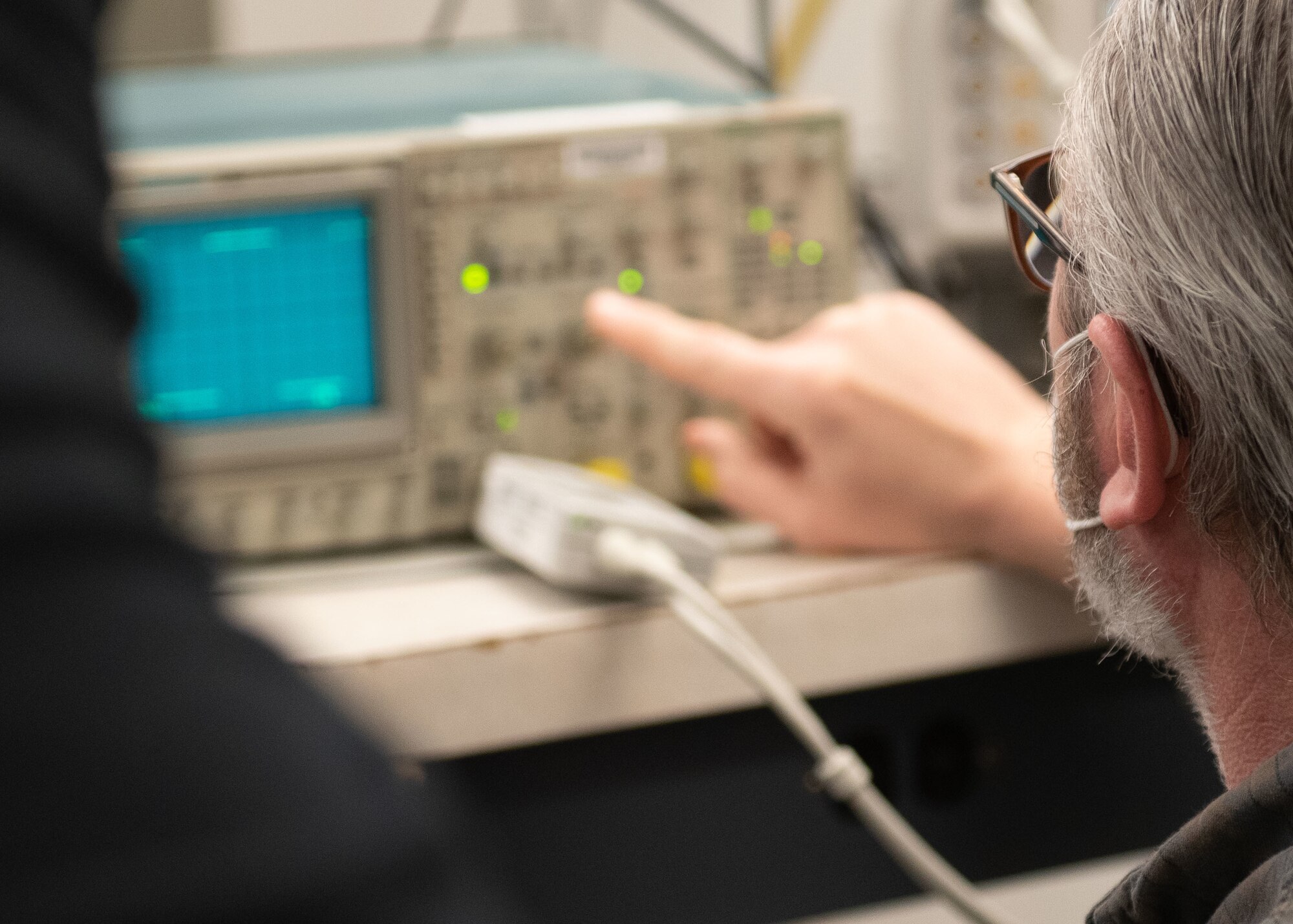 A PMEL technician points to a piece of calibration equipment