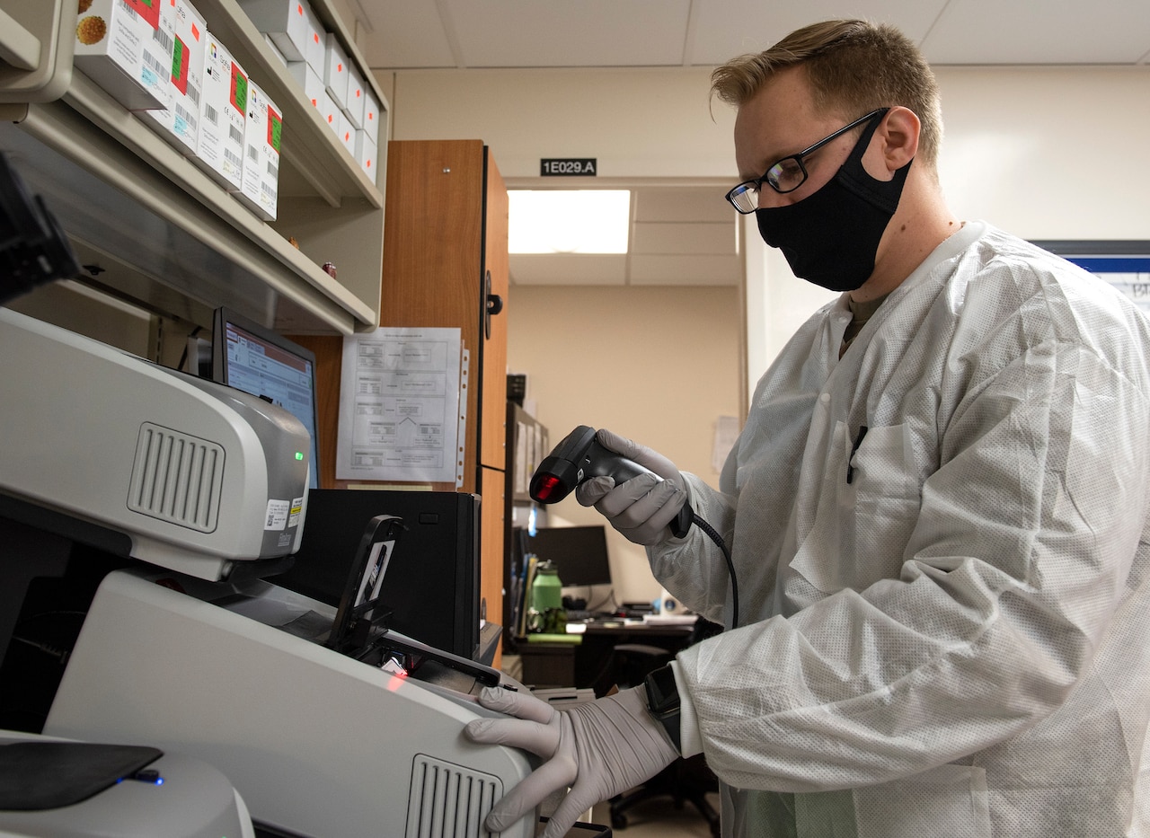 A lab technician scans a COVID-19 sample.
