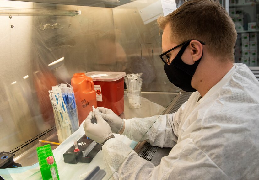 A lab technician handles medical samples.