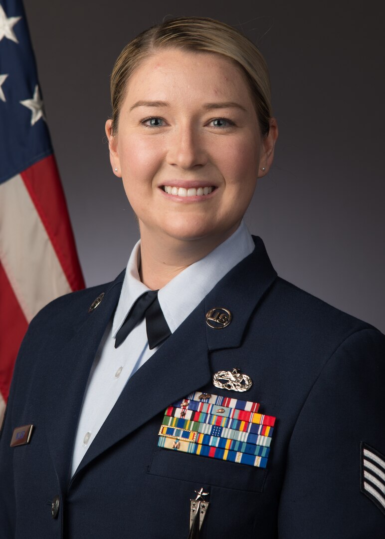 A studio photograph of a female Airman in her blues uniform