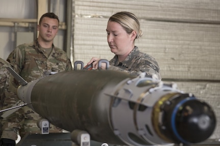 An Airman working on an inert missal in bomb build training