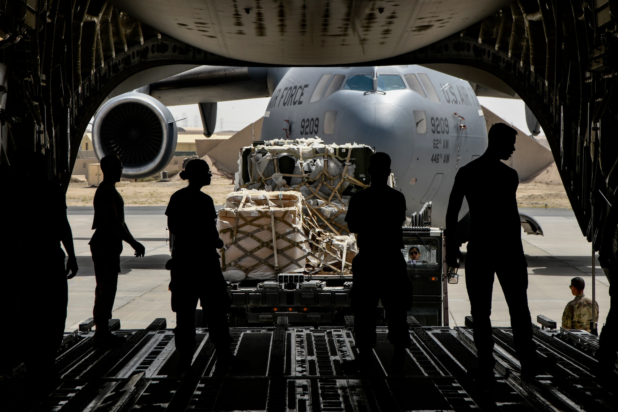 Airmen secure cargo onto aircraft.