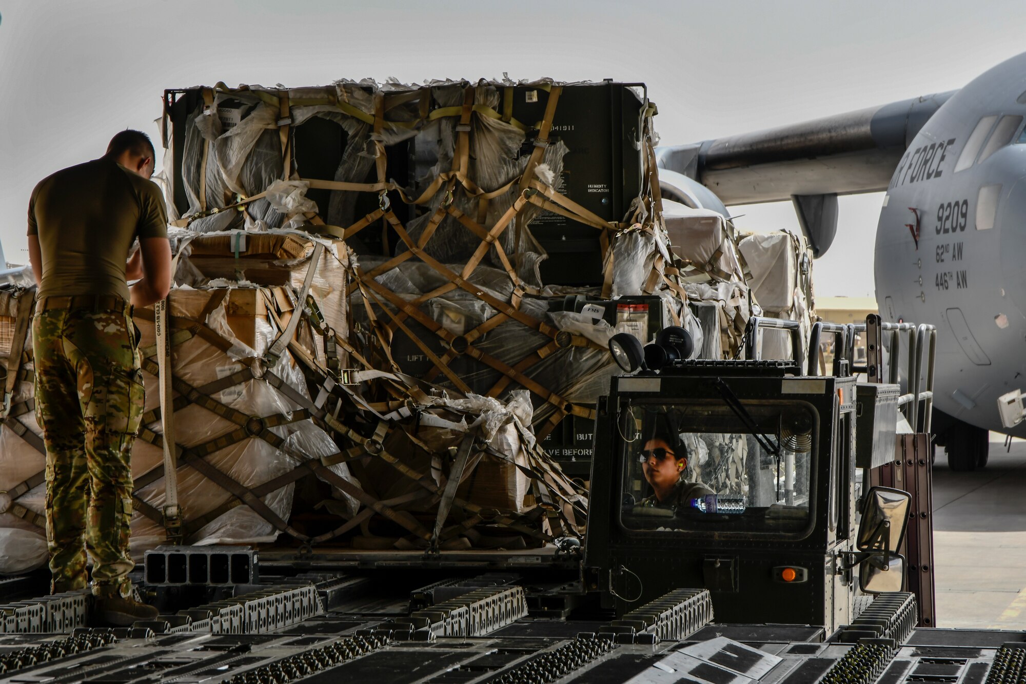 Airmen load cargo onto aircraft.