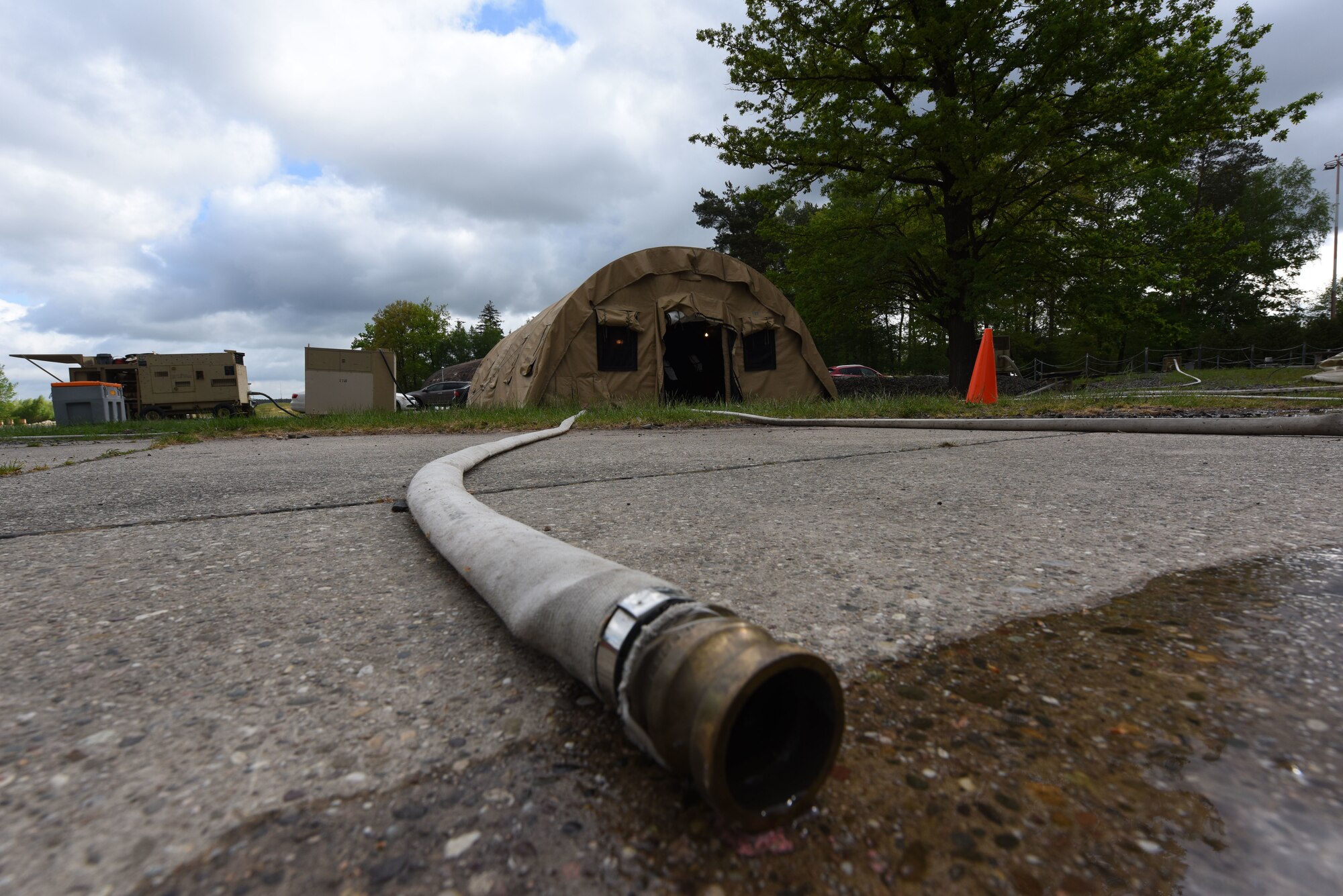 Water pours out of a fire hose at a 435th Construction and Training Squadron training site.