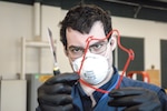 Scott Ziv, an engineer in the Additive Manufacturing Project Office at Naval Surface Warfare Center Carderock Division, inspects a set of face covering frames after they were 3D printed on April 14, 2020, in Carderock’s Manufacturing, Knowledge and Education Lab in West Bethesda, Md.