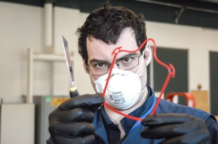 Scott Ziv, an engineer in the Additive Manufacturing Project Office at Naval Surface Warfare Center Carderock Division, inspects a set of face covering frames after they were 3D printed on April 14, 2020, in Carderock’s Manufacturing, Knowledge and Education Lab in West Bethesda, Md.