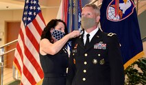 Brig. Gen. David F. Stewart, deputy commanding general for operations, U.S. Army Space and Missile Defense Command, receives his one-star rank during a ceremony at the command’s Peterson Air Force Base, Colorado, headquarters, May 4 from his wife, Annie. (U.S. Army photo by Dottie White)