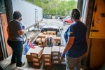 Employees and volunteers with the Mountaineer Food Bank help distribute supplies to volunteers with a local food bank from a newly created food distribution center at the West Virginia National Guard's Rock Branch facility in Poca, West Virignia, May 05, 2020. The new center is a joint effort between the West Virginia National Guard (WVNG), West Virginia Voluntary Organizations Active in Disasters (VOAD), Mountaineer Food Bank, Facing Hunger Food Bank, and the West Virginia Division of Homeland Security and Emergency Management (WVDHSEM) as the need for supplemental and emergency food services continues to grow across the Mountain State during the ongoing COVID-19 pandemic. (U.S. Army National Guard photo by Edwin L. Wriston)