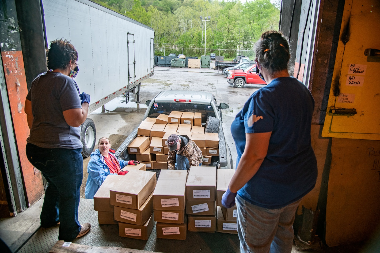 Employees and volunteers with the Mountaineer Food Bank help distribute supplies to volunteers with a local food bank from a newly created food distribution center at the West Virginia National Guard's Rock Branch facility in Poca, West Virignia, May 05, 2020. The new center is a joint effort between the West Virginia National Guard (WVNG), West Virginia Voluntary Organizations Active in Disasters (VOAD), Mountaineer Food Bank, Facing Hunger Food Bank, and the West Virginia Division of Homeland Security and Emergency Management (WVDHSEM) as the need for supplemental and emergency food services continues to grow across the Mountain State during the ongoing COVID-19 pandemic. (U.S. Army National Guard photo by Edwin L. Wriston)
