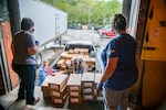 Employees and volunteers with the Mountaineer Food Bank help distribute supplies to volunteers with a local food bank from a newly created food distribution center at the West Virginia National Guard's Rock Branch facility in Poca, West Virignia, May 05, 2020.