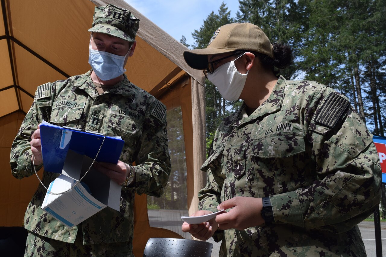 A Navy medical officer mans a screening post.