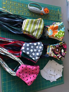 Colorful masks siting on a green cutting grid.