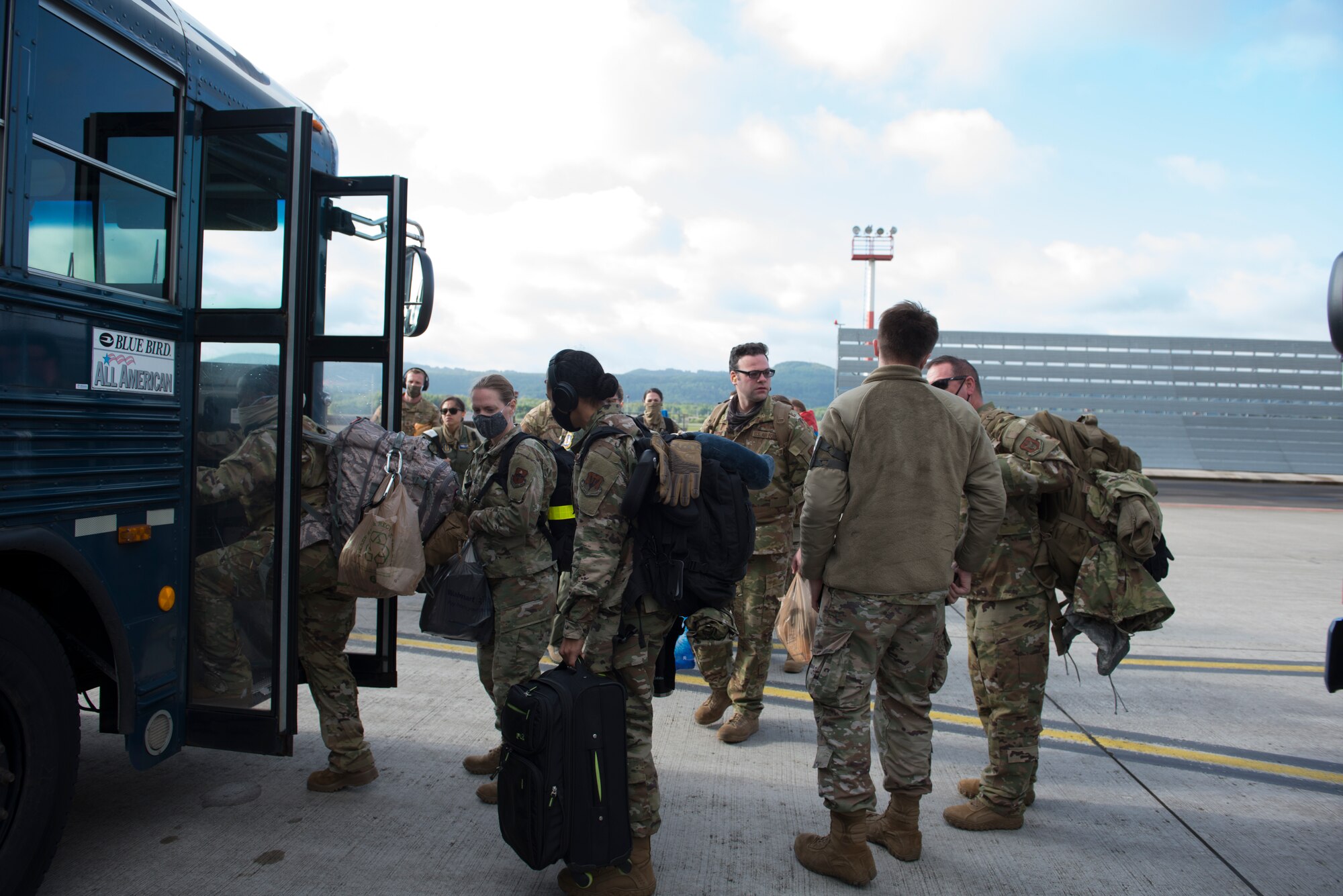 A photo of Airmen stepping onto a bus.