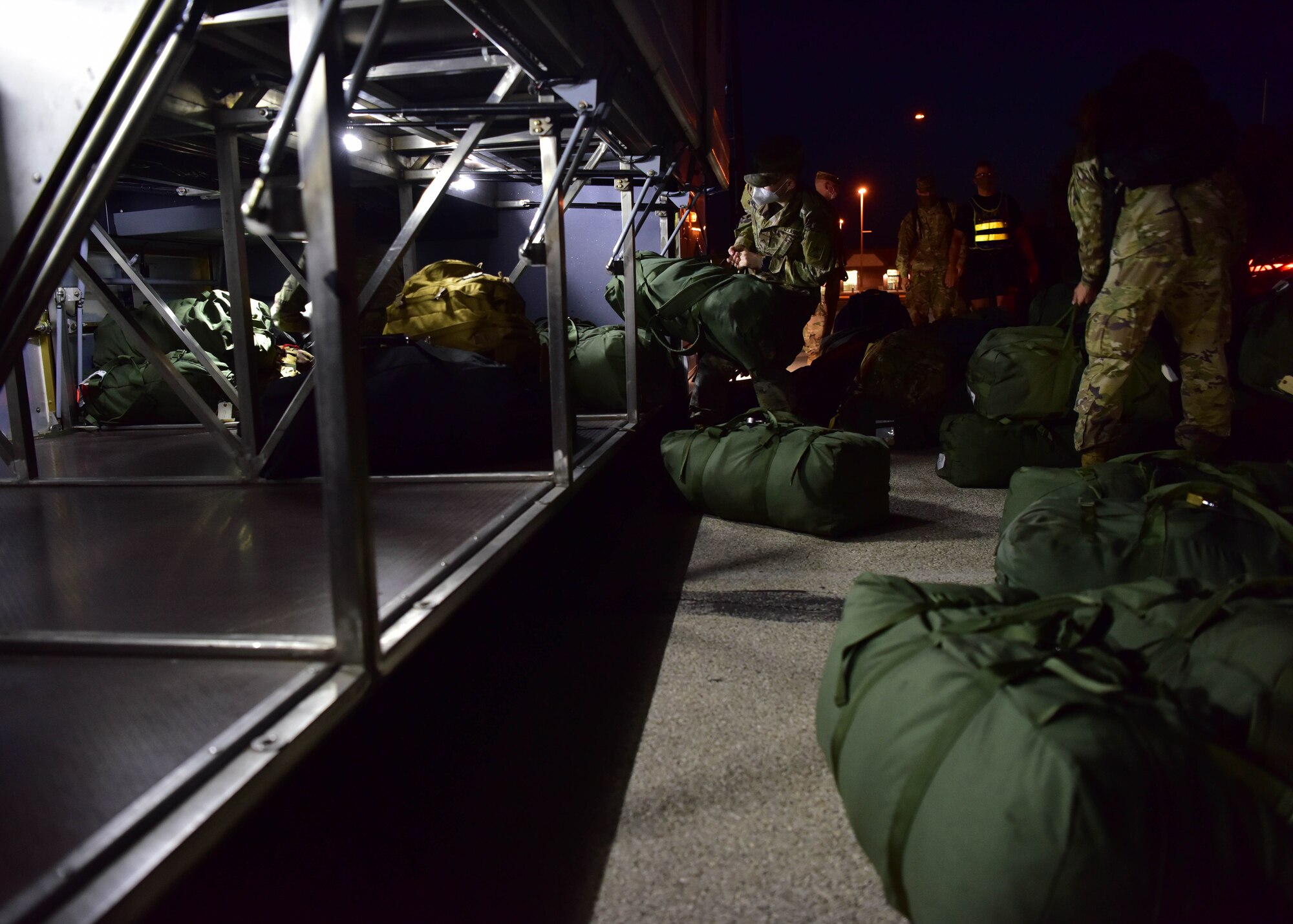 Soldiers with the 344th Military Intelligence Battalion load their bags onto a bus on Goodfellow Air Force Base, Texas, May 5, 2020. The Soldiers were the first class of U.S. Army intelligence graduates to move to their operational units during the COVID-19 restrictions. (U.S. Air Force photo by Staff Sgt. Chad Warren)