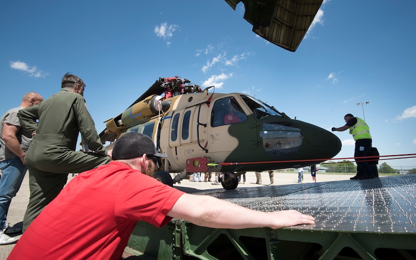Team members from a Huntsville-based defense industry contractor, SES-i, who refurbished these two UH-60 Black Hawk helicopters for Afghanistan under a U.S Army Security Assistance Command foreign military sales case, prepare to upload the helicopters into an Antonov AN-124, at the airfield in Huntsville, Alabama, April 26, 2019.  US Army photo by Richard Bumgardner, USASAC Public Affairs.