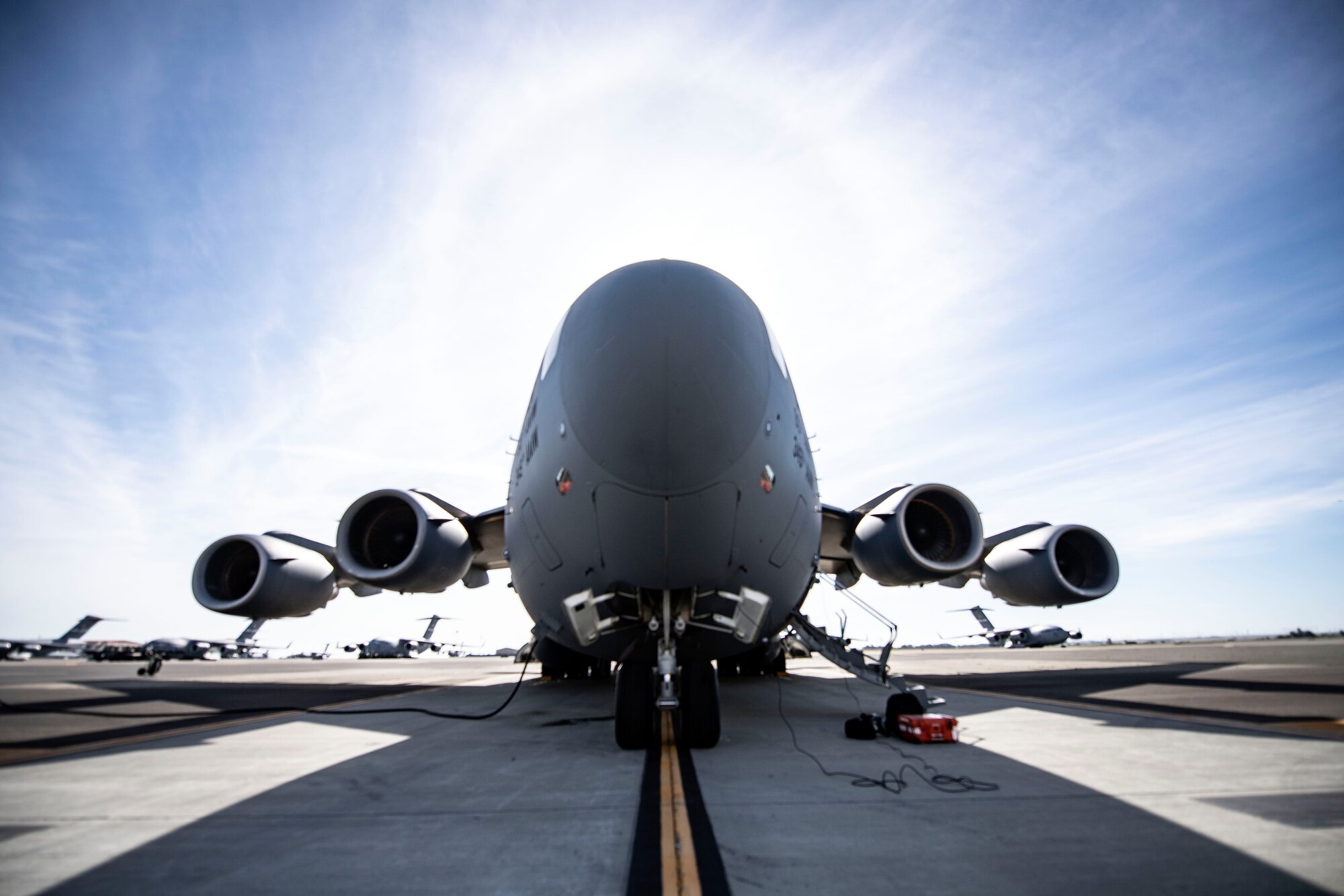 A C-17 Globemaster III is parked on the Travis flight line April 27, 2020, at Travis Air Force Base, California. As of now, only the C-17, C-130H Hercules and C-130J Super Hercules are capable of carrying Transport Isolation System capsules. TIS capsules, which were initially engineered in response to the Ebola virus in 2014, allow the transport of individuals with highly contagious diseases without infecting any other passengers or aircrew on the aircraft. (U.S. Air Force photo by Senior Airman Christian Conrad)
