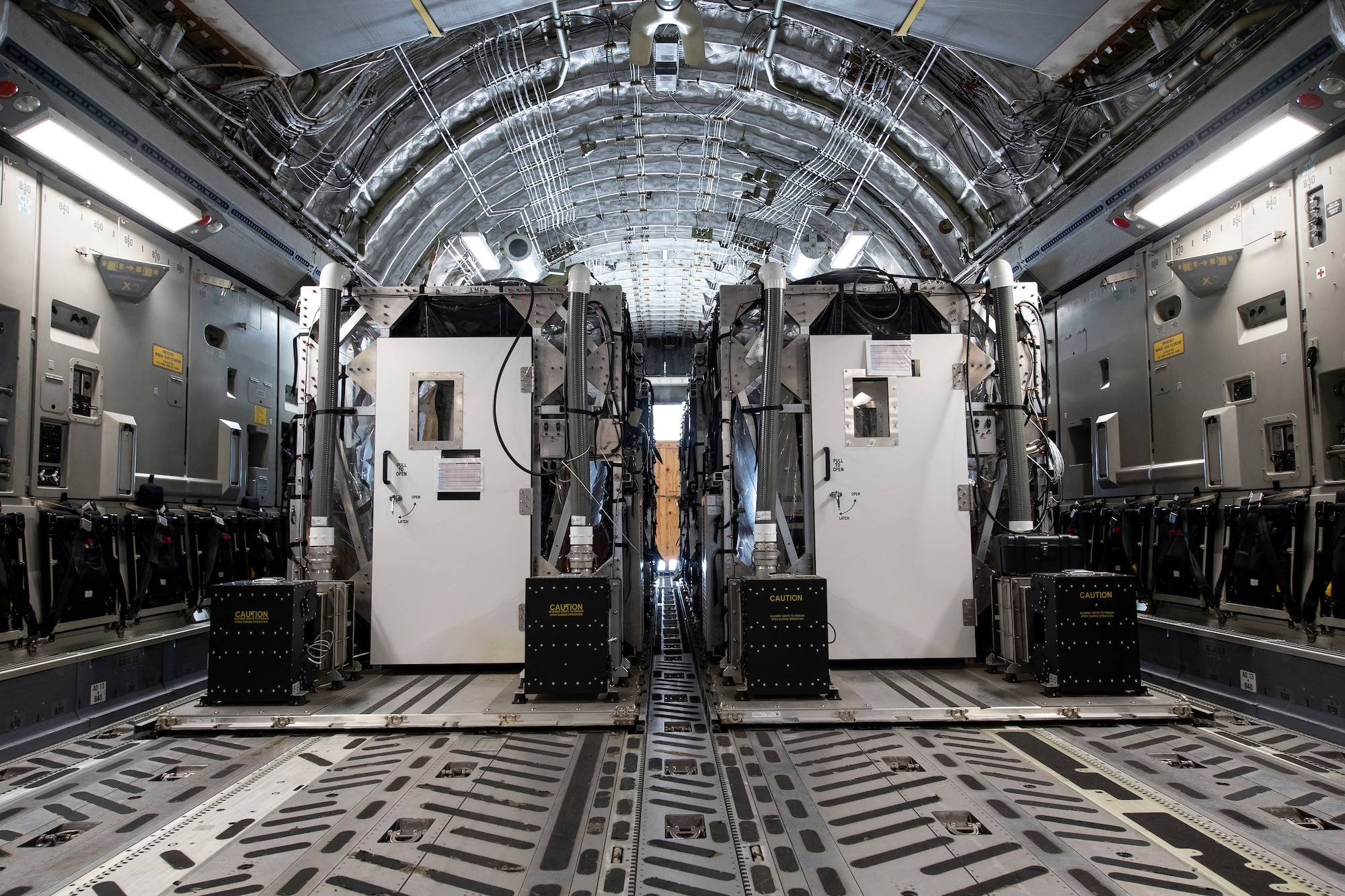 Two Transport Isolation System capsules are placed in the cargo bay of a C-17 Globemaster III April 28, 2020, at Travis Air Force Base, California. TIS capsules, which were initially engineered in response to the Ebola virus in 2014, allow the transport of individuals with highly contagious diseases without infecting any other passengers or aircrew on the aircraft. (U.S. Air Force photo by Senior Airman Christian Conrad)