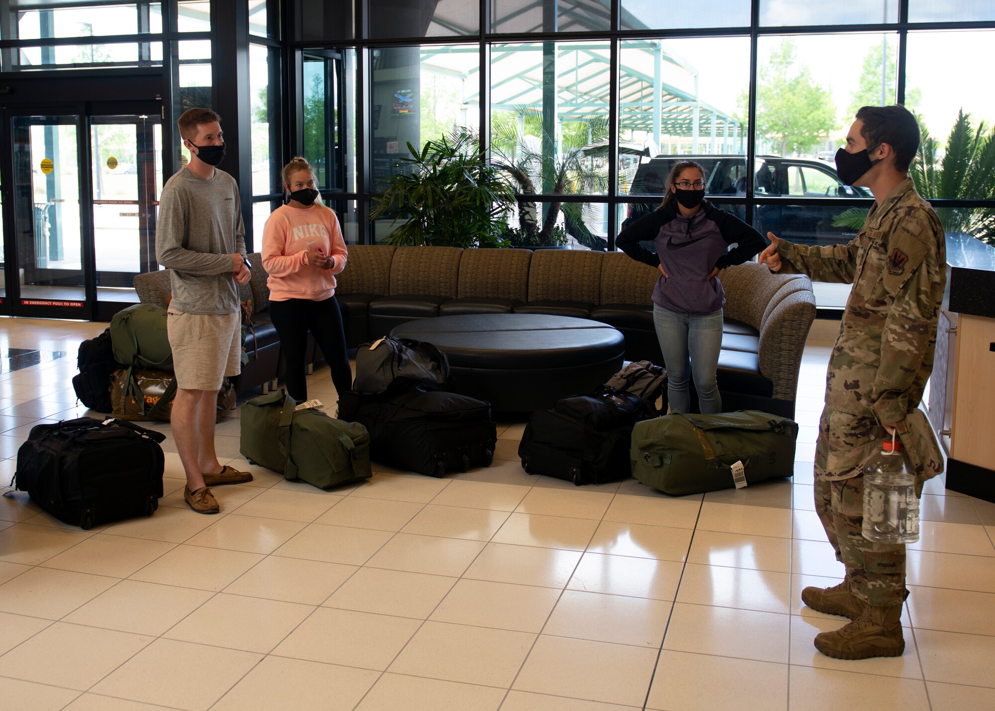A member of Task Force Roadrunner briefs Airmen on new inprocessing procedures at the Northwest Florida Beaches International Airport in Panama City, Florida, May 5, 2020. Task Force Roadrunner was established at Tyndall Air Force Base to allow technical training graduates to safely inprocess during the COVID-19 Pandemic. (U.S. Air Force photo by Brad Sturk)