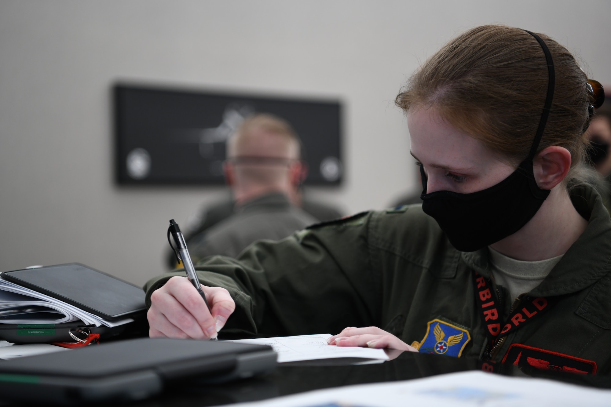 A 34th Bomb Squadron aviator writes mission information for a non-stop deployment from Ellsworth Air Force Base, S.D., May 4, 2020. Bomber deployments and operations enhance the readiness and training necessary to respond to any contingency or challenge across the globe. (U.S. Air Force photo by Airman Quentin Marx)
