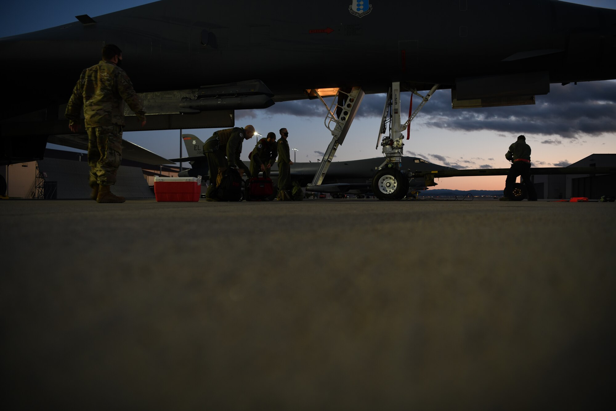 Wing leaders assist aviators assigned to the 34th Bomb Squadron unload their gear after successfully completing a more than 25-hour non-stop deployment from Ellsworth Air Force Base, S.D., May 5, 2020. During the Bomber Task Force mission to the U.S. European Command area of responsibility, B-1B Lancers integrated with NATO and allied partners for operations and activities. (U.S. Air Force photo by Senior Airman Nicolas Z. Erwin)