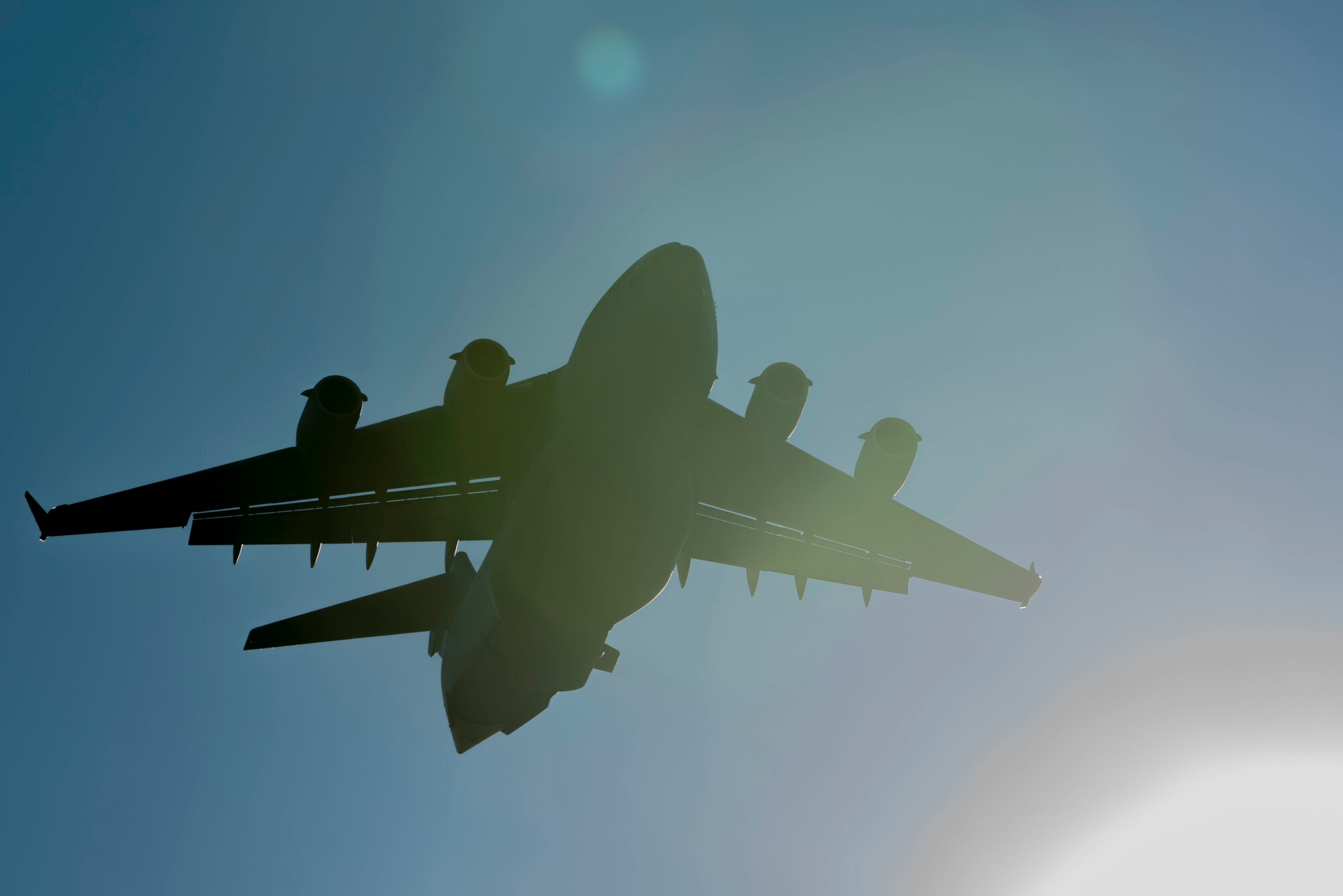 A U.S. Air Force C-17 Globemaster III flies over the flightline during an elephant walk, May 5, 2020, at Joint Base Elmendorf-Richardson, Alaska. The large show-of-force demonstrated the wings’ rapid mobility capabilities and response readiness during COVID-19 and also highlighted the ability to generate combat airpower at a moment’s notice to ensure regional stability throughout the North American Aerospace Defense Command Region and Indo-Pacific.