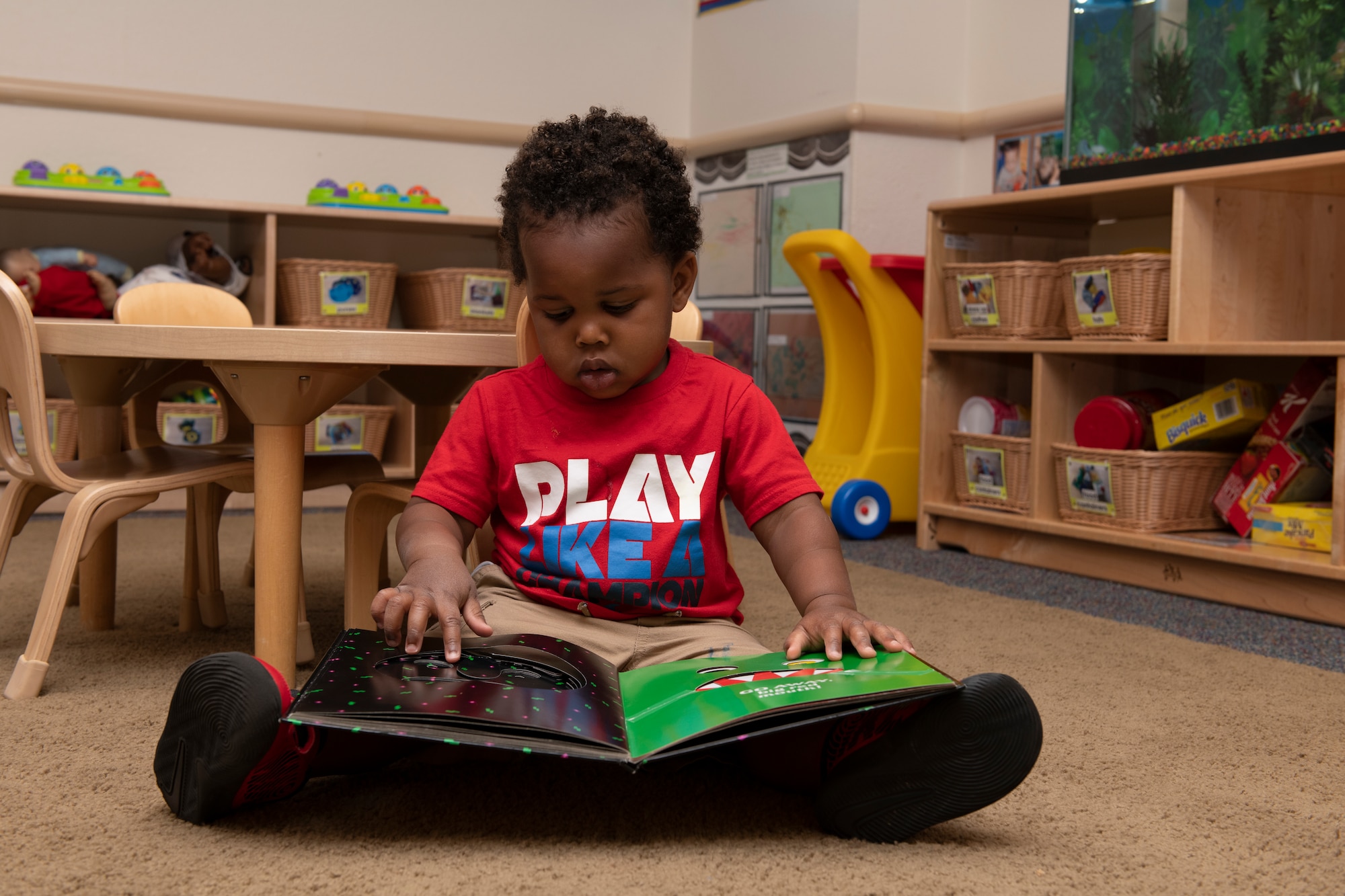 A child reads a book May 1, 2020, inside Child Development Center 3 at Travis Air Force Base, California. The center is one of three childcare centers at Travis AFB that provide care for children from six weeks to 5-years-old. (U.S. Air Force photo by Tech. Sgt. James Hodgman)