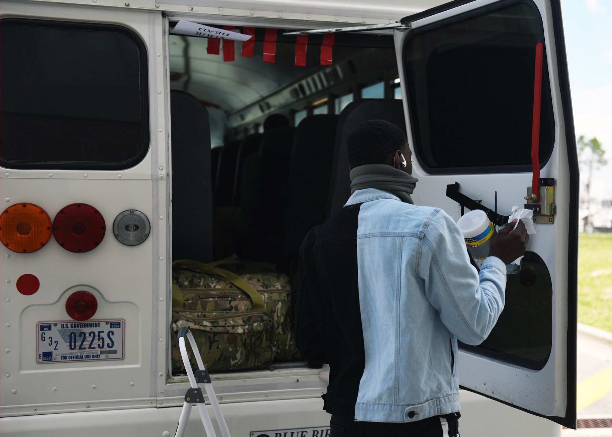 An Airman sanitizes after loading their luggage at the Northwest Florida Beaches International Airport in Panama City, Florida, May 5, 2020. Tyndall Air Force Base established Task Force Roadrunner to safely accommodate technical training graduates arriving for their first duty station during a pandemic. (U.S. Air Force photo by Brad Sturk)