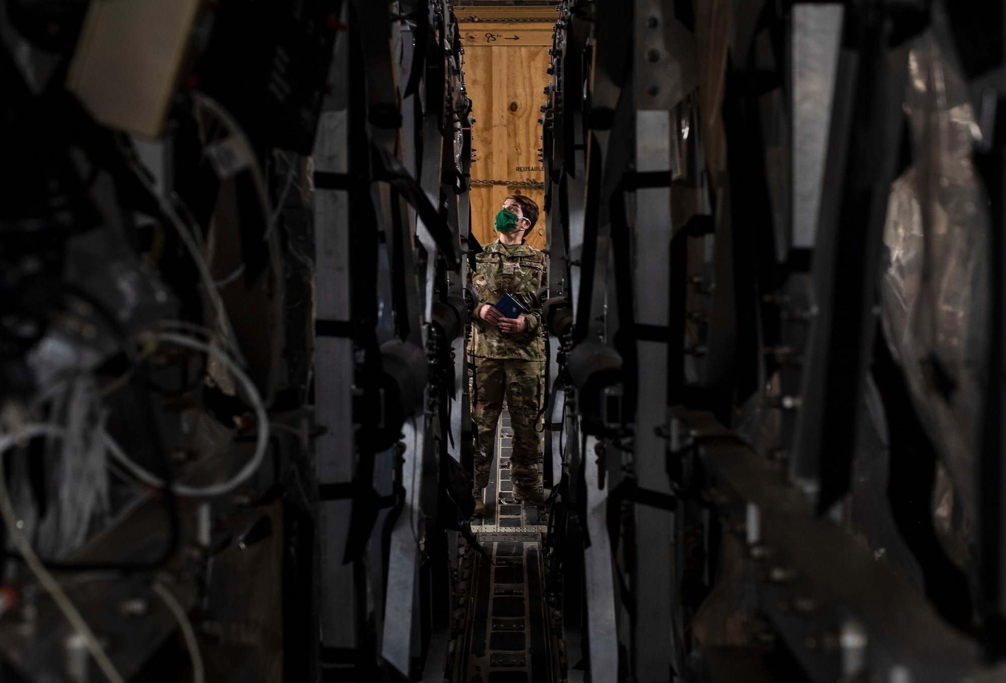 U.S. Air Force Chief Master Sgt. Jennifer Moses, 775th Expeditionary Aeromedical Evacuation Flight, COVID West AE Task Force member, examines two Transport Isolation System capsules April 28, 2020, at Travis Air Force Base, California. The task force’s aim is to research and implement best practices to help combat and prevent the spread of COVID-19. (U.S. Air Force photo by Senior Airman Christian Conrad)