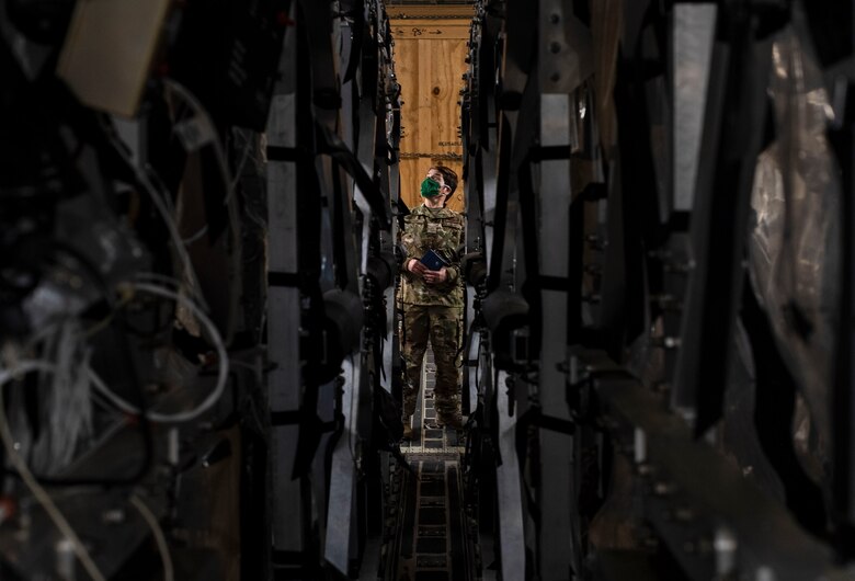 U.S. Air Force Chief Master Sgt. Jennifer Moses, 775th Expeditionary Aeromedical Evacuation Flight, COVID West AE Task Force member, examines two Transport Isolation System capsules April 28, 2020, at Travis Air Force Base, California. The task force's aim is to research and implement best practices to help combat and prevent the spread of COVID-19. (U.S. Air Force photo by Senior Airman Christian Conrad)