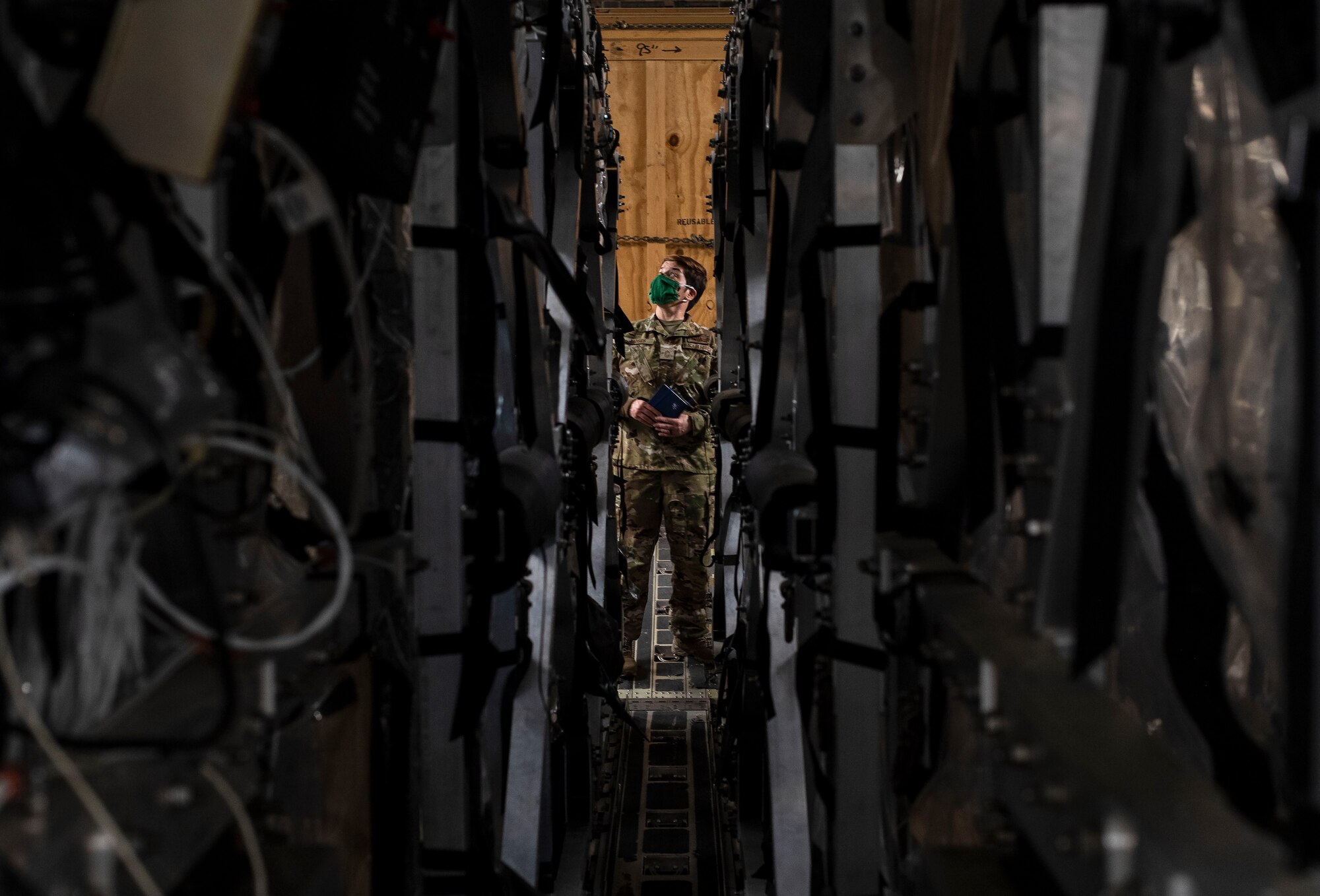 U.S. Air Force Chief Master Sgt. Jennifer Moses, 775th Expeditionary Aeromedical Evacuation Flight, COVID West AE Task Force member, examines two Transport Isolation System capsules April 28, 2020, at Travis Air Force Base, California. The task force’s aim is to research and implement best practices to help combat and prevent the spread of COVID-19. (U.S. Air Force photo by Senior Airman Christian Conrad)