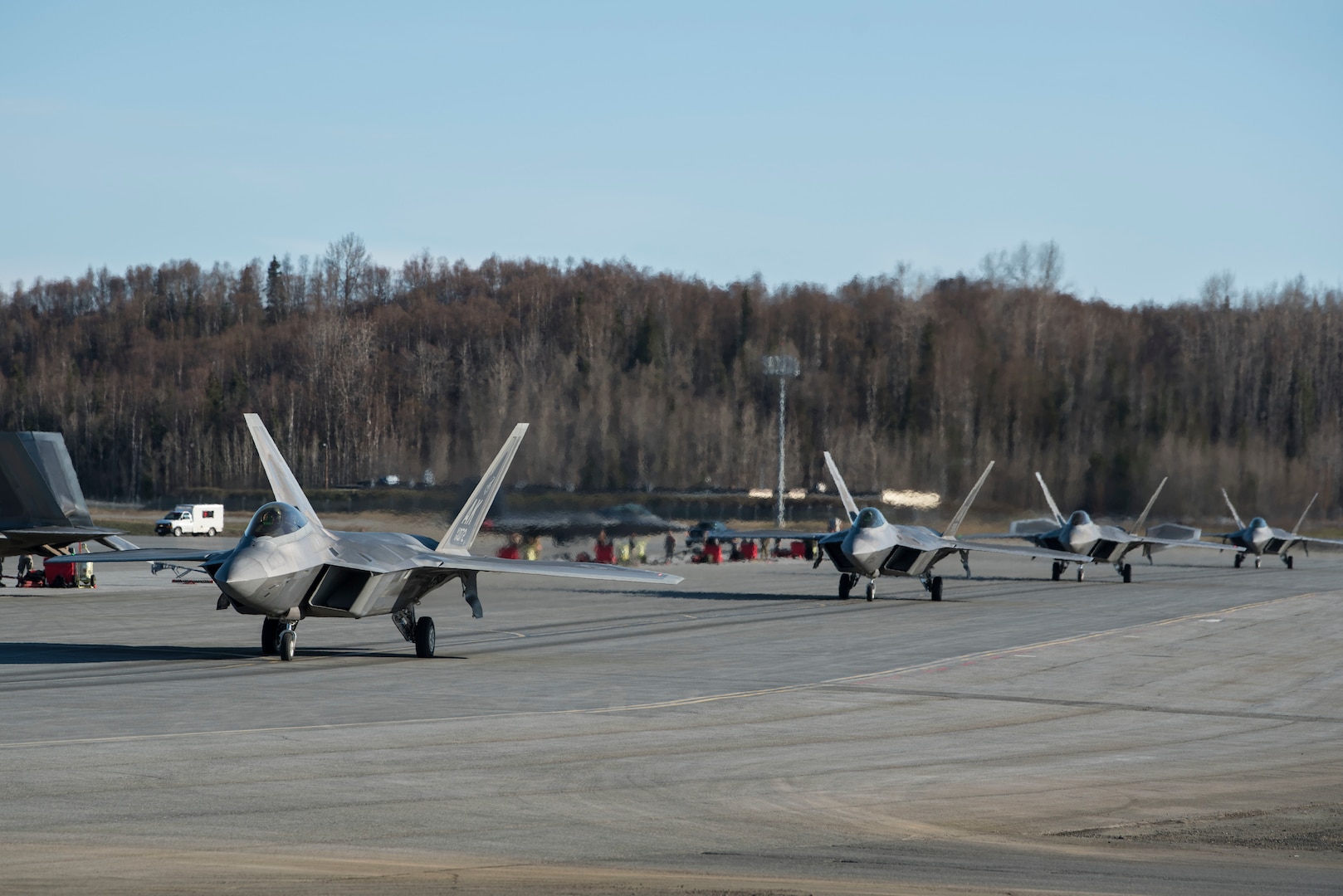 U.S. Air Force F-22 Raptors taxi onto the runway prior to an elephant walk, May 5, 2020, at Joint Base Elmendorf-Richardson, Alaska. This event displayed the ability of the 3rd Wing, 176th Wing and the 477th Fighter Group to maintain constant readiness throughout COVID-19 by Total Force Integration between active-duty, Guard and Reserve units to continue defending the U.S. homeland and ensuring a free and open Indo-Pacific.