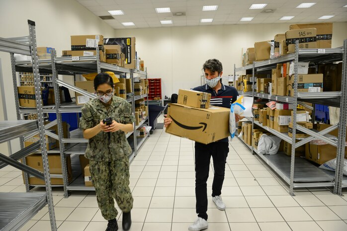 NAPLES, Italy (April 30, 2020) Francesco Ciccarelli, postal clerk (right), and Logistics Specialist Seaman Oralia Ortiz sort and organize incoming mail at the Naval Support Activity (NSA) Naples Support Site post office, attached to Naval Supply Systems Command Fleet Logistics Center (NAVSUP FLC) Sigonella, April 30, 2020. Commander, U.S. Naval Forces Europe-Africa/ U.S. 6th Fleet, headquartered in Naples, Italy, oversees joint and naval operations, often in concert with Allied, joint, and interagency partners, in order to advance U.S. national interests and security and stability in Europe and Africa. (U.S. Navy photo by Mass Communication Specialist Chief Justin Stumberg/Released)