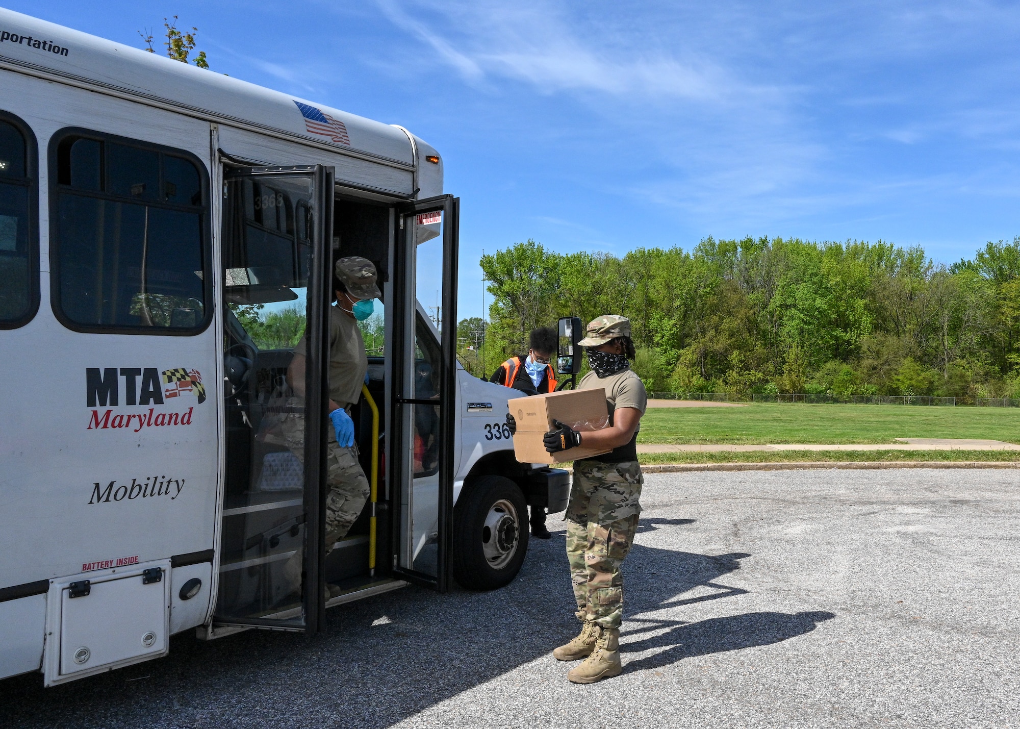 Members of the Maryland Air National Guard place boxes of groceries on a Maryland Transportation Mobility bus for a member of the community while supporting efforts by the Maryland Food Bank and Baltimore County Department of Parks and Recreation to distribute meals and groceries at the Mars Estates Police Athletic League center in Essex, Md., May 2, 2020. The mission helps food insecure citizens have enough while schools and work places are closed. (U.S. Air National Guard photo by Tech. Sgt. Enjoli Saunders)
