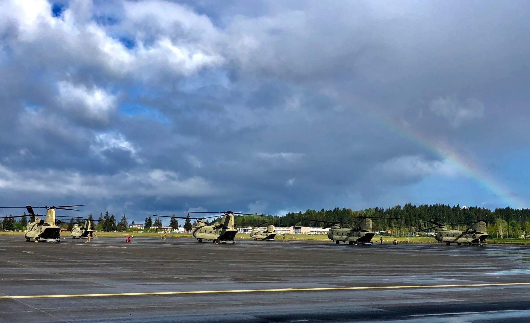 After a rainy morning a rainbow appears over the CH-47 Chinook helicopters during Bravo Company, 1st Battalion, 168th General Support Aviation deployment ceremony at the Washington Army National Guard Army Aviation Support Facility at Joint Base Lewis-McChord, Washington, May 6, 2020. Bravo Company is set to deploy to the Middle East for the third time in 10 years.
