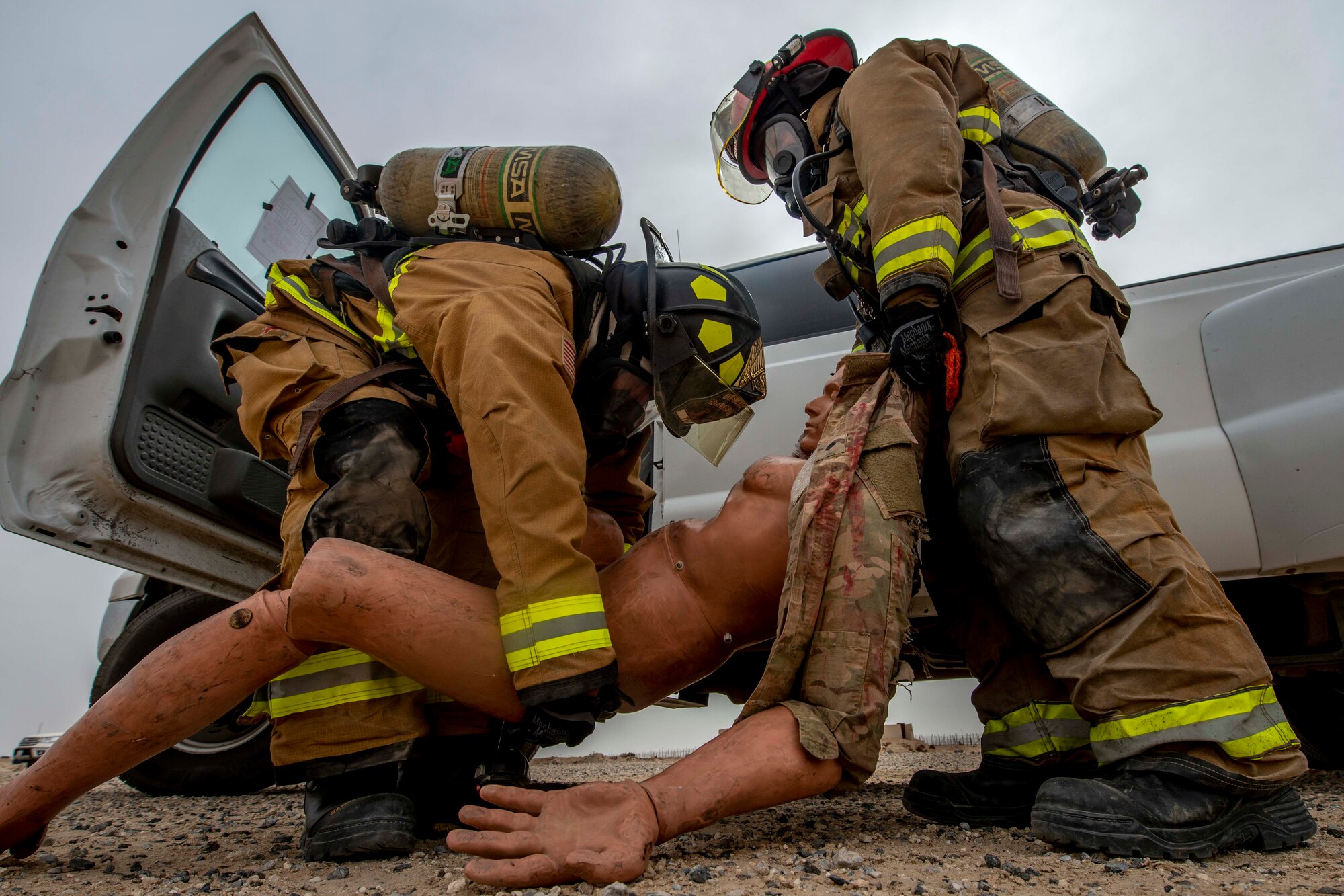 Senior Airman Michael Tuck and Staff Sgt. Tyrique Jackson, 386th Expeditionary Civil Engineer Squadron firefighters, carry a training mannequin during an all-hazard training exercise at Ali Al Salem Air Base, Kuwait, May 5, 2020. The exercise was designed to enhance interoperability between multiple first responder teams with the goal of responding, identifying and controlling potential real-world scenarios. (U.S. Air Force photo by Senior Airman JaNae Capuno)