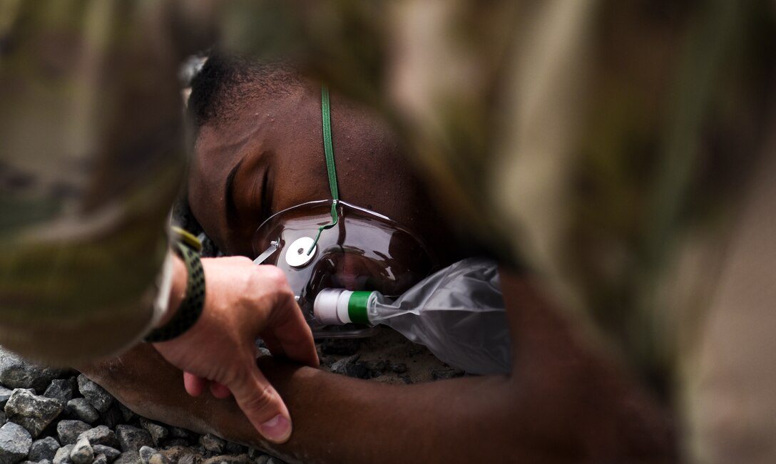 A 386th Expeditionary security Forces Squadron member assists a simulated casualty during an all hazard exercise at Ali Al Salem Air Base, Kuwait, May 5, 2020. Responding agencies practiced their skills together to build cohesion and learn each other's capabilities during the all-hazard response exercise. (U.S. Air Force photo by Senior Airman Kevin Tanenbaum)