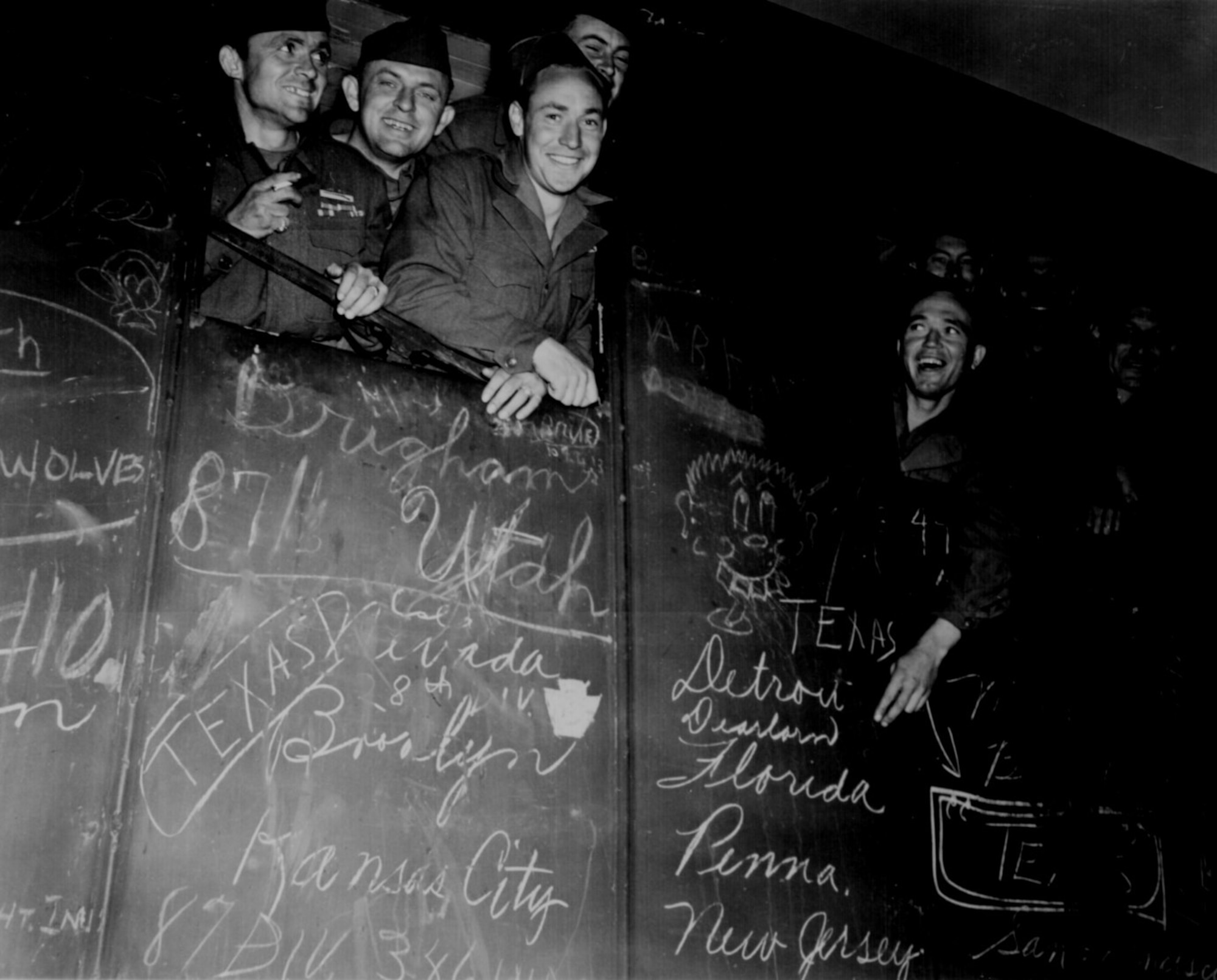 American service members ride a train toward the harbor of Le Havre, France, May 25, 1945 following the German surrender.