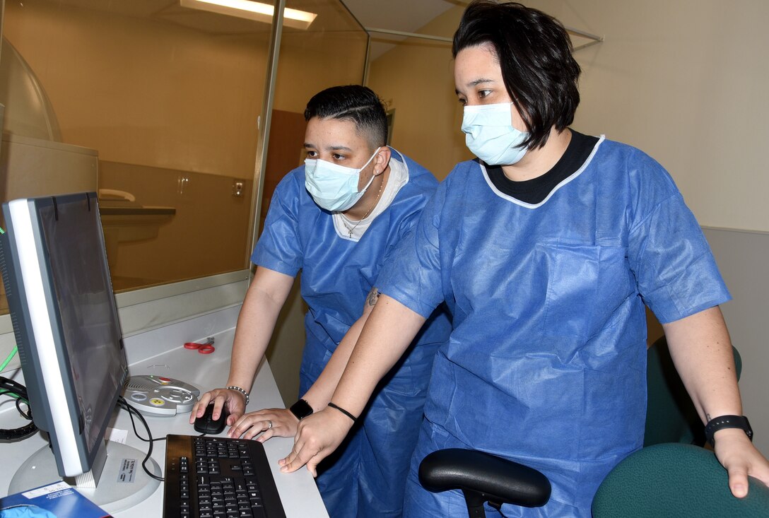 Senior Airman Arianna E. Teran (left) and Staff Sgt. Courtney E. Herrera, 436th Medical Support Squadron diagnostic imaging technicians work on a computer during training on a new Computed Tomography (CT) scanner at the Armed Force Medical Examiner System, Dover Air Force Base, Del., April 30, 2020. The scanner can reveal anatomic details of internal organs that would not be seen in conventional X-rays. (U.S. Air Force photo by Tech. Sgt. Robert M. Trujillo)