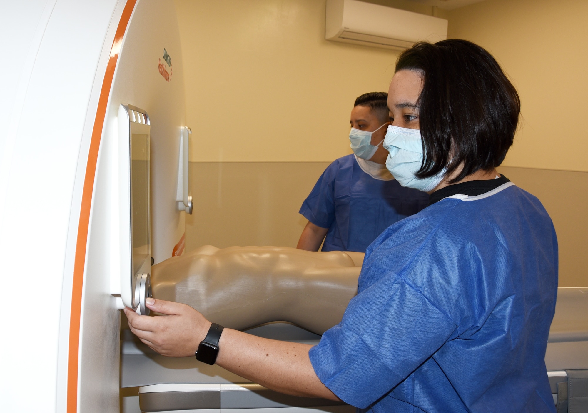 Staff Sgt. Courtney E. Herrera (front), 436th Medical Support Squadron diagnostic imaging technician trains on a new Computed Tomography (CT) scanner at the Armed Force Medical Examiner System, Dover Air Force Base, Del., April 30, 2020. By custom designing the scanner for forensic operations, AFMES saved the Department of Defense an estimated $700,000, compared to the cost of hospital CT scanners.  (U.S. Air Force photo by Tech. Sgt. Robert M. Trujillo)